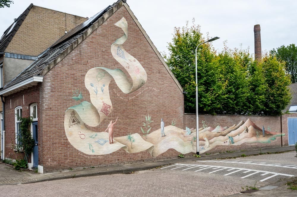 Muurschildering Een ode aan hen die van heinde en verre zijn gekomen van Tja Ling Hu uit 2023
